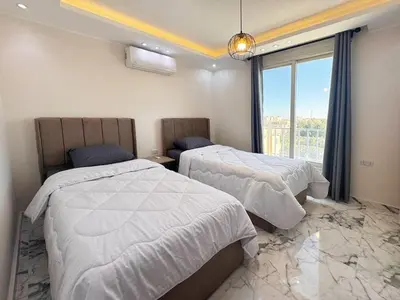 a hotel room with two beds and a window at 2 bedrooms in Hurghada Hub Resort in Hurghada
