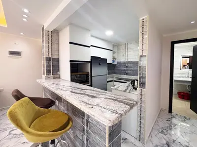 a kitchen with a counter and a yellow chair at 2 bedrooms in Hurghada Hub Resort in Hurghada