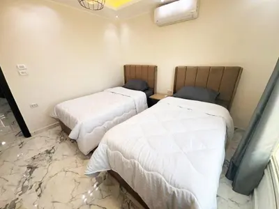 two beds in a room with marble floors at 2 bedrooms in Hurghada Hub Resort in Hurghada