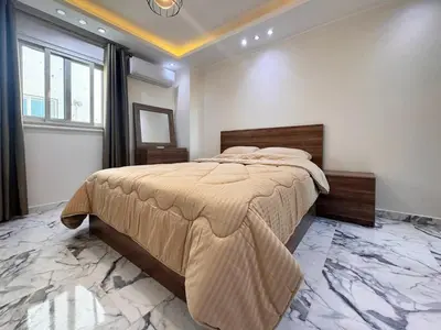 a bedroom with a large bed with a marble floor at 2 bedrooms in Hurghada Hub Resort in Hurghada