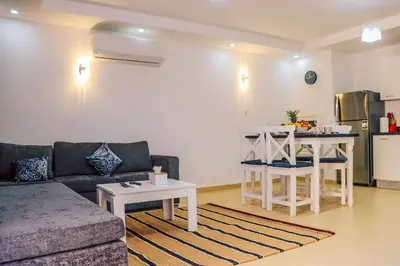 a living room with a couch and a table and a kitchen at Selena Bay Resort in Hurghada