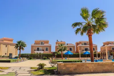 a building with palm trees in front of it at Selena Bay Resort in Hurghada