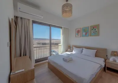a bedroom with a large bed and a large window at Brand-New 1BR in Kamaran El Gouna I Pool View & Access in Hurghada
