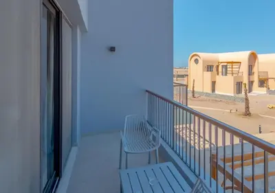 a balcony with a bench and a blue wall at Brand-New 1BR in Kamaran El Gouna I Pool View & Access in Hurghada