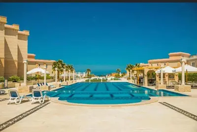 a large swimming pool with chairs and umbrellas at selena bay resort in El Gouna