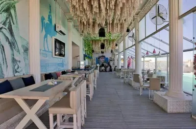 a dining room with tables and chairs and windows at selena bay resort in El Gouna