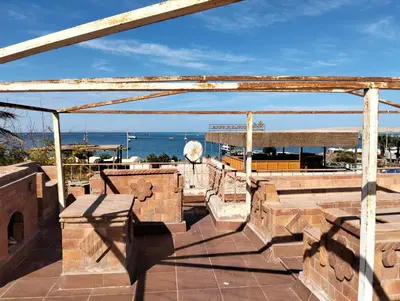 a patio with benches and a view of the ocean at AL Sarfi Apartments in Hurghada