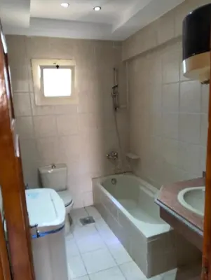 a bathroom with a tub and a toilet and a sink at AL Sarfi Apartments in Hurghada