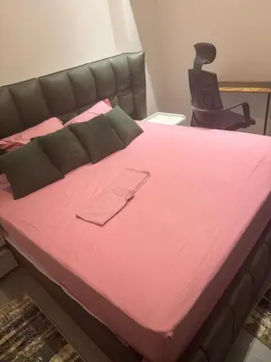 a large bed with pink sheets and a chair at Luxury 3BD Makadi Heights phase 2 Orascom in Hurghada