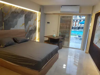 a bedroom with a bed and a view of a pool at Taiba Golden Resort in Hurghada