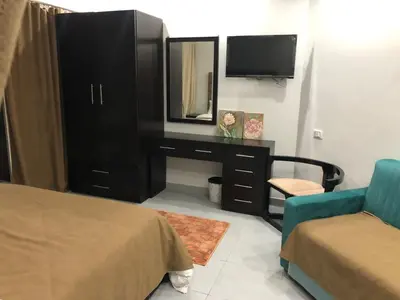 a bedroom with a dresser with a mirror and a tv at scandic Resort hurghada in Hurghada