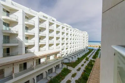 an external view of a white building with a garden at scandic Resort hurghada in Hurghada