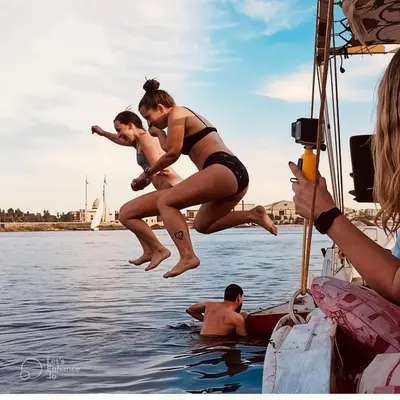 two girls jumping into the water from a boat at sailboat in Luxor