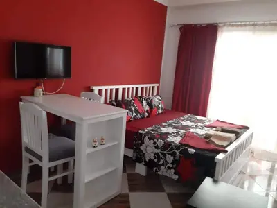 a bedroom with a bed and a desk and a tv at Sheraton Plaza 421 in Hurghada