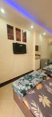 a room with two beds and a tv on the wall at Apartment With Free Private Beach Furnished Near senzomall in Hurghada