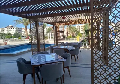 a patio at a resort with tables and chairs at -Hurghada HUB Resort-Peaceful Getaway in Hurghada