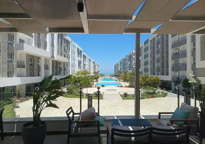 a patio with a view of a pool and buildings at Fanadir Bay - beach & Aquapark in Hurghada