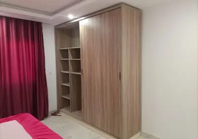 a wooden closet in a bedroom with a red curtain at Fanadir Bay - beach & Aquapark in Hurghada