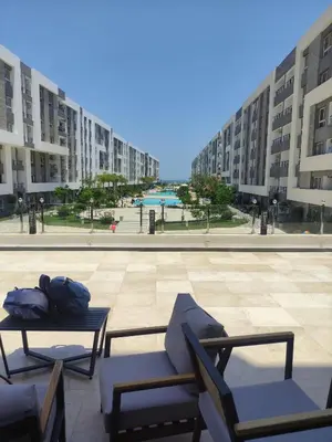 two chairs and a table in a courtyard with buildings at Hurghada Fanader bay in Hurghada