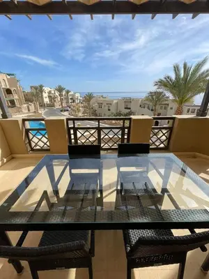 a glass table and chairs on a balcony at Seaview Apartment in Azzurra Sahl Hasheesh 2 bedrooms in Hurghada