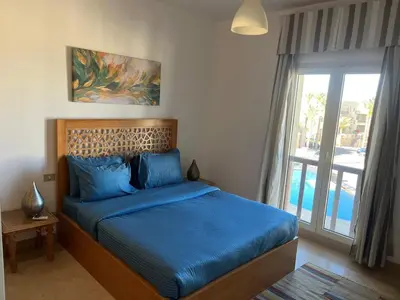 a bedroom with a bed with blue sheets and a window at Seaview Apartment in Azzurra Sahl Hasheesh 2 bedrooms in Hurghada