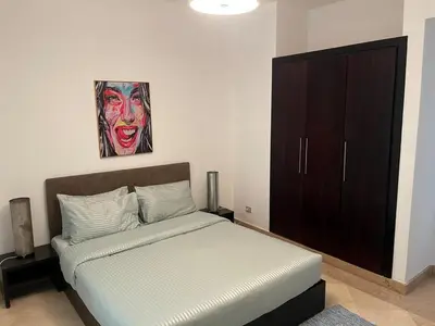 a bedroom with a bed and a painting on the wall at Seaview Apartment in Azzurra Sahl Hasheesh 2 bedrooms in Hurghada