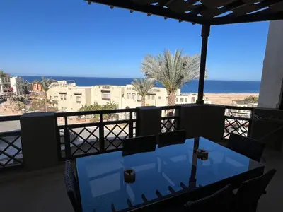 a table on a balcony with a view of the ocean at Seaview Apartment in Azzurra Sahl Hasheesh 2 bedrooms in Hurghada