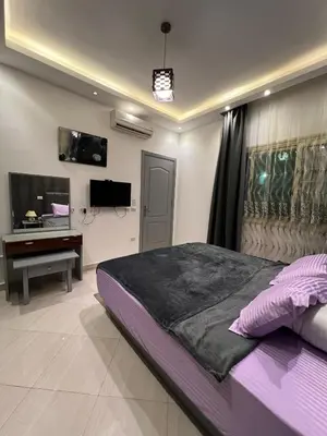 a bedroom with a large bed and a television at Sunflower cozy apartment in Hurghada