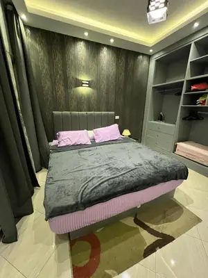 a bedroom with a bed with pink pillows on it at Sunflower cozy apartment in Hurghada