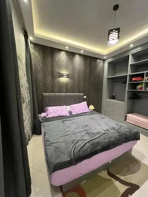 a bedroom with a bed with pink pillows on it at Sunflower cozy apartment in Hurghada