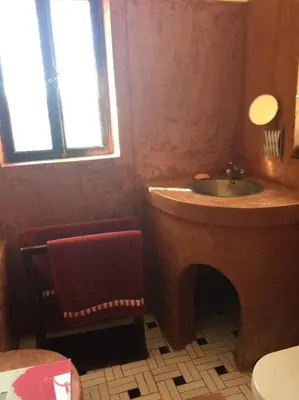 a bathroom with a sink and a chair and a window at فيلا نوبيا بجوار بيتش الزيتونه in Hurghada