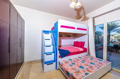 a bedroom with a bunk bed and a bunk bed ladder at Apartment Azzura Sahl Hasheesh with Private Garden and Sea view in Hurghada