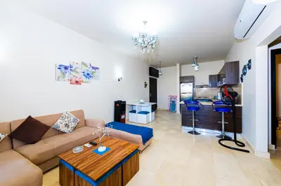 a living room with a couch and a table at Apartment Azzura Sahl Hasheesh with Private Garden and Sea view in Hurghada