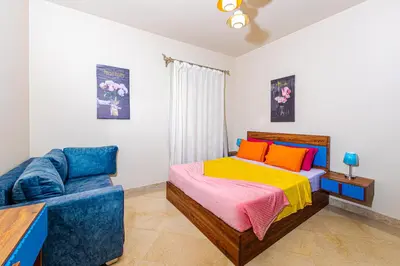 a bedroom with a bed and a blue couch at Apartment Azzura Sahl Hasheesh with Private Garden and Sea view in Hurghada