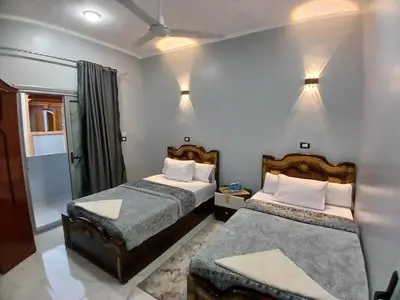 a hotel room with two beds and a window at Hakuna Matata in Aswan