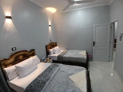 a small room with two beds and a door at Hakuna Matata in Aswan