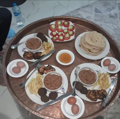 a table with plates of food and bowls of food at Hakuna Matata in Aswan