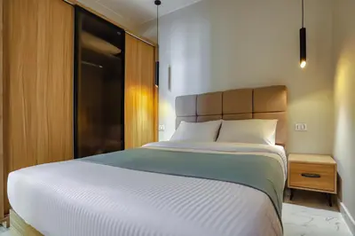 a bedroom with a large white bed and a night stand at La Prestigia luxury Apartments by Peaks in Hurghada