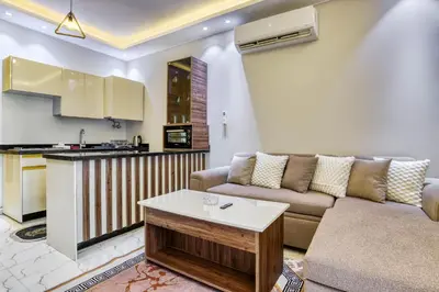 a living room with a couch and a kitchen at La Prestigia luxury Apartments by Peaks in Hurghada