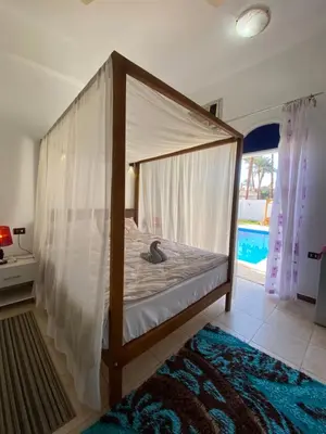 a bed with a canopy in a room at Villa Acamar in Al Karnak