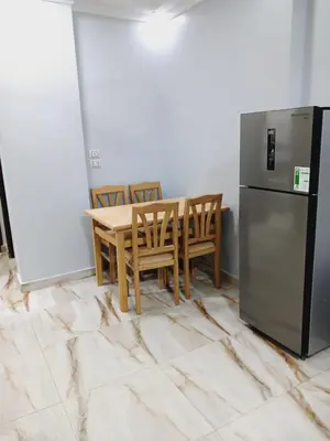 a kitchen with a table and a refrigerator at Hotel apartments in Hurghada