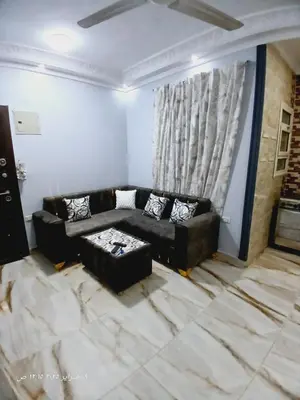 a living room with a black couch and a table at Hotel apartments in Hurghada