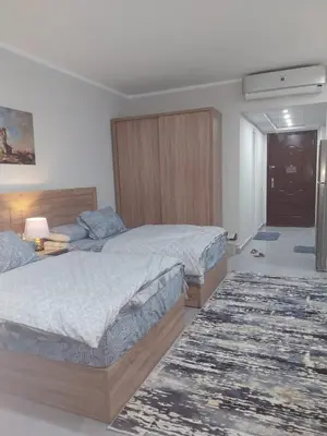 a bedroom with two beds and a rug at pola studio at scandic resort in Hurghada