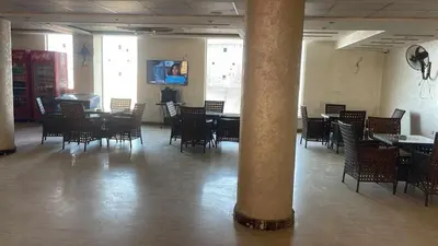 a dining room with tables and chairs and a column at Studio in Hurghada