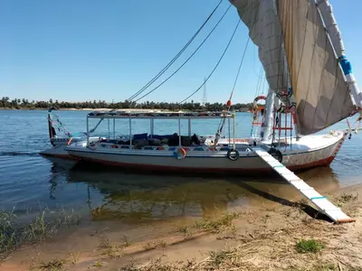a boat is docked on the shore at valleyofthenileadventures in Luxor