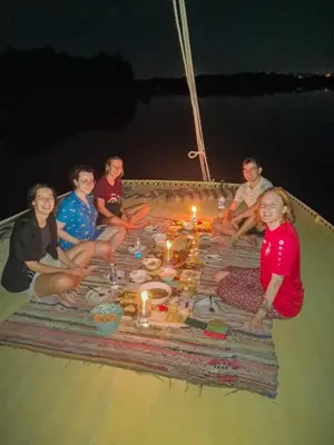 a group of people sitting around a table on a boat at valleyofthenileadventures in Luxor