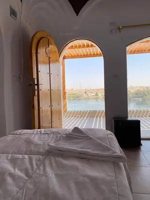a bedroom with two doors and a bed with a view at nubiary in Jazīrat Salūjah