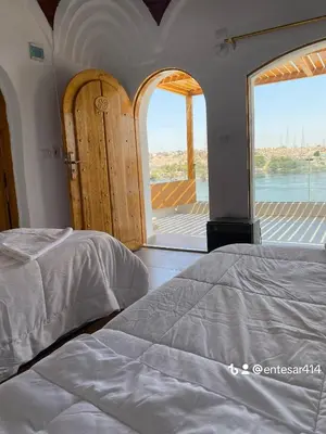 a bedroom with two beds and a large window at nubiary in Jazīrat Salūjah