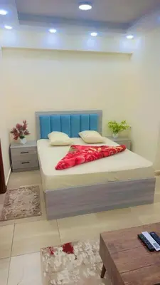 a bedroom with a bed with a blue headboard at Princess Resort 109 B Al Mamsha Al Seyahi in Hurghada