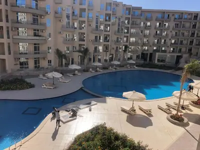 a large swimming pool in front of a large building at Princess Resort 109 B Al Mamsha Al Seyahi in Hurghada